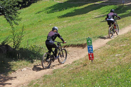 Couple cycling on mountain bike, rides mountain trail.の写真素材