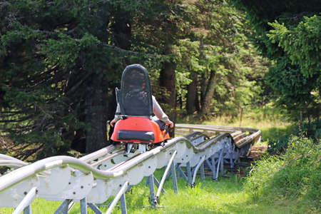 Little boy enjoying a summer fun roller alpine coaster ride in Rogla, Sloveniaの写真素材