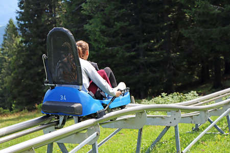 Two young girls enjoying a summer fun roller alpine coaster ride in Rogla, Sloveniaの写真素材