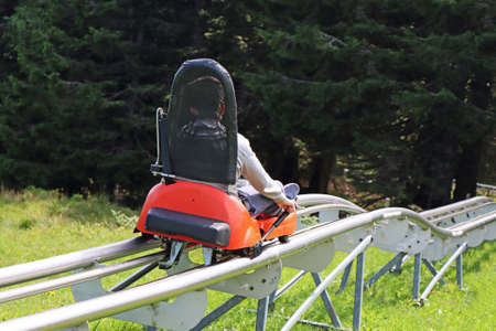 Little boy enjoying a summer fun roller alpine coaster ride in Rogla, Sloveniaの写真素材