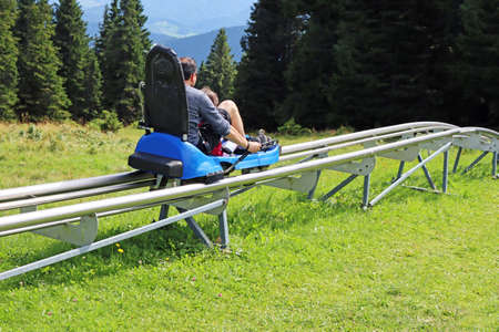 Father and son enjoying a summer fun roller alpine coaster ride in Rogla, Sloveniaの写真素材