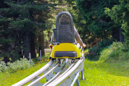 Young girl enjoying a summer fun roller alpine coaster ride in Rogla, Sloveniaの写真素材