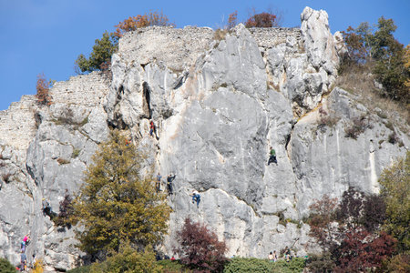 Group of young people climbing natural high rocky wall on Kalnik, Croatiaの写真素材