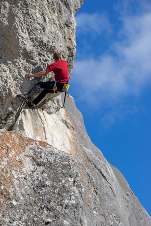 Young sports man climbing natural high rocky wall on Kalnik, Croatiaの写真素材