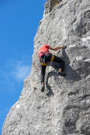 Young male climber climbs on a cliffの写真素材
