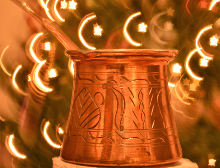 Photo of Ibrik or also known as cezve, a small long-handled pot with a pouring lip designed specifically to make Turkish coffee with crescent and star backgroundの写真素材