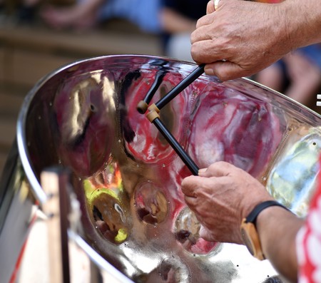 Musicians hands are skillfully performing calypso music with a Jamaican steel drumの写真素材