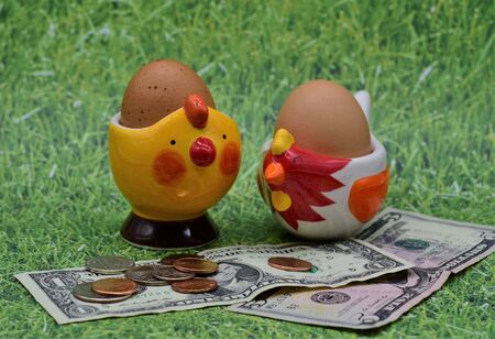 Two brown chicken eggs are displayed together with dollar bills depicting rising food costsの写真素材