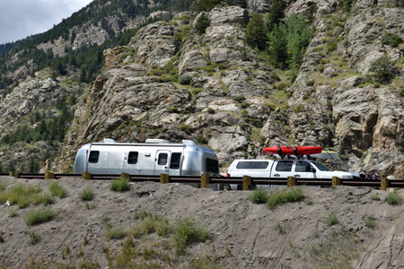 Truck pulling camper up with kayak on top on Colorado rocky mountain roadの写真素材