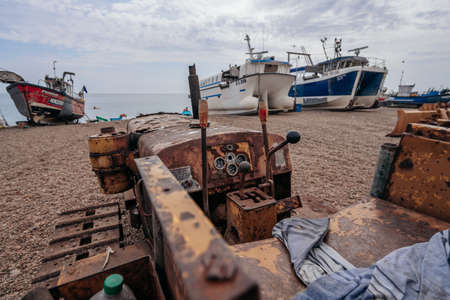 Hastings Port, East Sussex / UK -  2020.08.08: Bulldozers at Hastings fishing boats on the beach at Rock-a-Noreの写真素材
