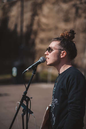 Chiswick, West London | UK -  2021.03.21: Street musician singer singing in front of the small crowd on sunny dayのeditorial素材