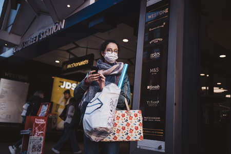 Soho, London | UK -  2021.04.16: Woman in mask with full shoping bags at Oxford street after lockdownのeditorial素材