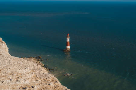 Red and whiteâstriped Beachy Head Lighthouse against chalk cliffs,  view from top of Seven Sisters, Clifftop Paths Nature Reserve. South of Englandの写真素材