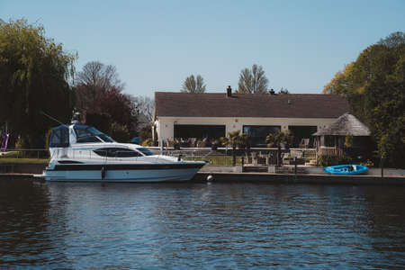 Staines-upon-Thames, Spelthorne
 | UK -  2021.04.24: Boats moored next to the beautiful houses on the river Thames in Stainesのeditorial素材