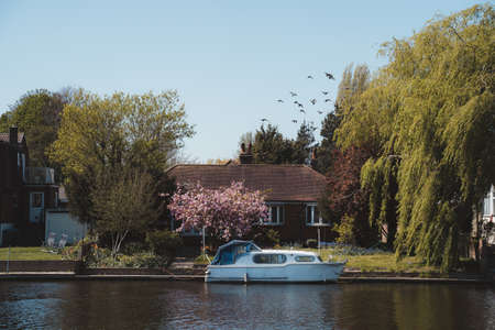 Staines-upon-Thames, Spelthorne
 | UK -  2021.04.24: Boats moored next to the beautiful houses on the river Thames in Stainesのeditorial素材