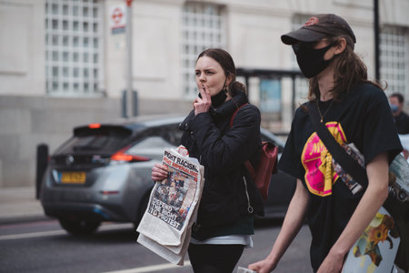 Westminster, London | UK -  2021.05.01: Girl smoking cigarette with mask on her chin and socialist...