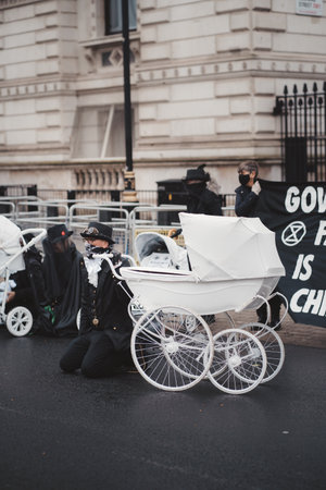 Westminster, London | UK -  2021.05.08: Extinction Rebellion activists kneeling in front of Downing Street with White Baby Pramsのeditorial素材