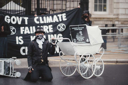 Westminster, London | UK -  2021.05.08: Extinction Rebellion activists kneeling in front of Downing Street with White Baby Pramsのeditorial素材