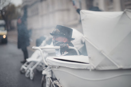 Westminster, London | UK -  2021.05.08: Extinction Rebellion activists kneeling in front of Downing Street with White Baby Prams with smoke granades in the backgroundのeditorial素材