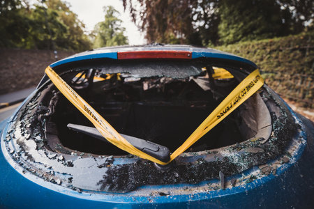 London | UK - 2021.06.12: An abandoned, stolen burnt out blue car parked on the sideway parking spotÐ± tied with yellow do not cross stripeのeditorial素材