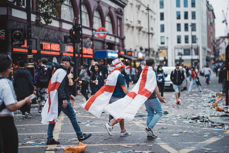 London | UK - 2021.07.12: Euro 2020 football fans walking down the road wearing English flags as a capesのeditorial素材