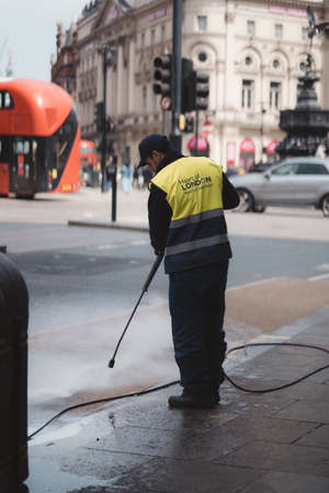 Westminster, London | UK -  2021.05.02: Man cleaning the sidewalks with high-pressureのeditorial素材