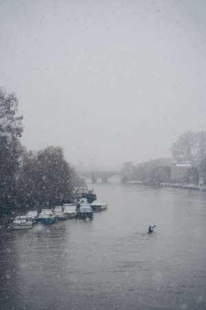Richmond Upon Thames, London | UK -  2021.01.24: Man in canoe on a snowy Sunday morning on the river Thamesのeditorial素材