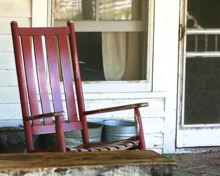 Red Rocking Chair on the Porch of an Old Farmhouseの写真素材