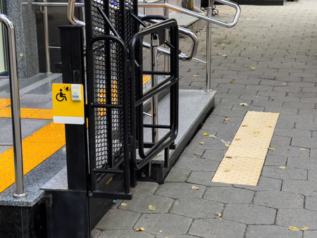 A ramp with a yellow sign that says handicap accessible. The ramp is made of metal and has a yellow...