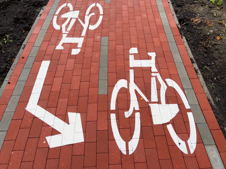 A clearly marked bike lane sign is painted on a red brick sidewalk, providing direction for cyclists...