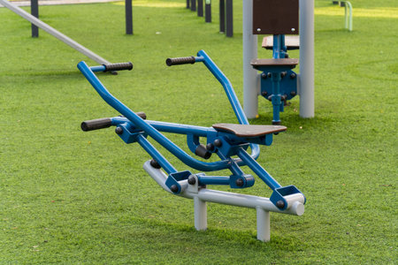 Outdoor fitness area features modern exercise machines designed for public use. Residents engage in physical activity to promote a healthy lifestyle surrounded by green spaces.の写真素材