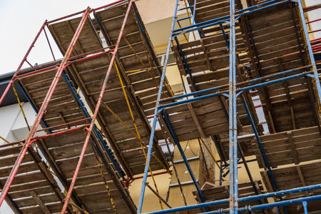 Workers rely on sturdy scaffolding to safely navigate and complete building projects at a construction site in progress.の写真素材