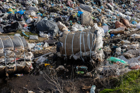 A vast landfill site displays layers of trash and debris, highlighting the ongoing issue of...