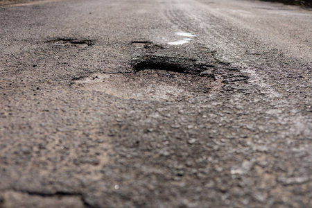 A significant crack in the asphalt on a highway poses a danger for drivers, necessitating immediate maintenance and repair efforts.の写真素材