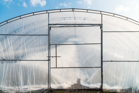 Soil greenhouse with plastic film outside view.の写真素材