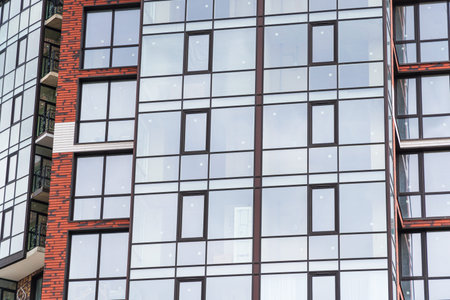 Modern luxury residential building with large windows. Exterior view of new multifamily residential...