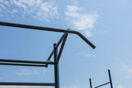 Empty parallel bars set in an outdoor gym, perfect for workout enthusiasts seeking an active...