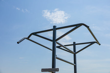 Two parallel horizontal bars stand in an outdoor gym, inviting fitness enthusiasts to engage in...