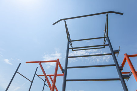 Bright outdoor fitness park features climbing structures reaching towards the sky, providing a...