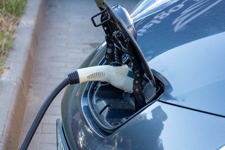 A modern electric vehicle is connected to a charging station, showcasing the importance of...