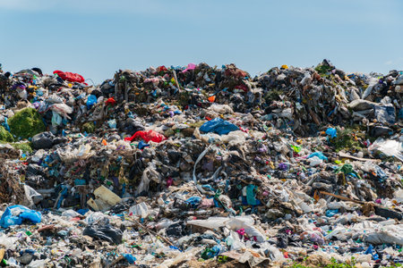 Large heaps of mixed waste cover a landfill, showcasing the severe pollution and ecological impact of garbage disposal practices on the environment.の写真素材