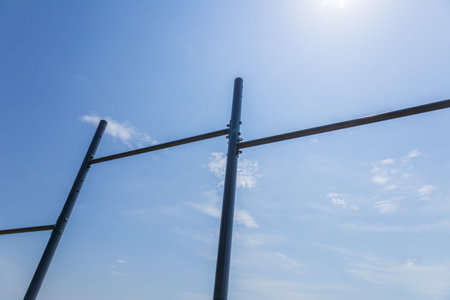 Horizontal bars stand in a park, encouraging athletes to perform training exercises on a sunny day with few clouds.の写真素材