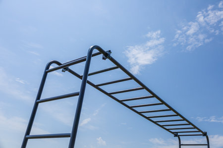 Horizontal bars in a park under a clear blue sky offer a great spot for outdoor exercise and fitness training sessions throughout the day.の写真素材