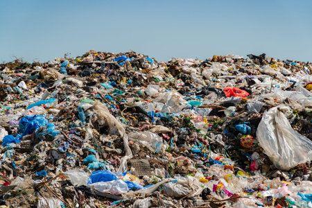 A sprawling landfill site overflowing with colorful plastic and other waste, contributing to...