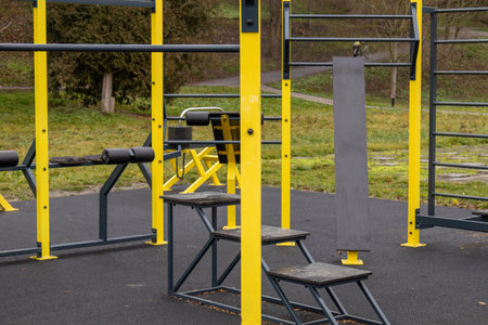 Fitness equipment in a park offers various workout options surrounded by trees and autumn leaves on...