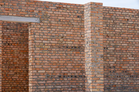 Sturdy bricks align perfectly in the sun, displaying skillful work at a construction site. The...