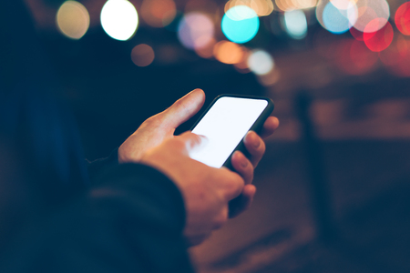 Man using smartphone outdoors. Night street.の写真素材