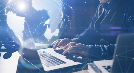 Man with laptop and abstract hologram of a globe. Interface and communication concept.の写真素材
