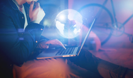 Man with laptop and abstract hologram of a globe. Interface and communication concept.