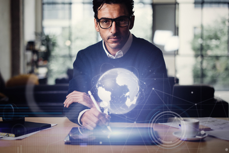 Man with digital tablet and abstract hologram of a globe. Interface and communication concept.の写真素材